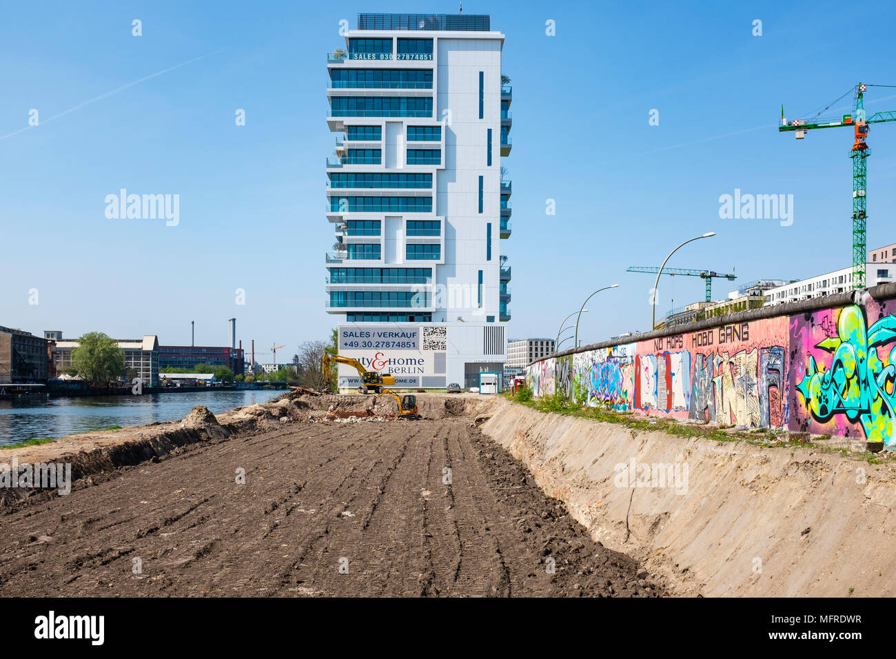 Vista della sezione originale del muro di Berlino e il controverso nuovo sito in costruzione dell edificio di appartamenti accanto al fiume Sprea a East Side Gallery in frittura Foto Stock