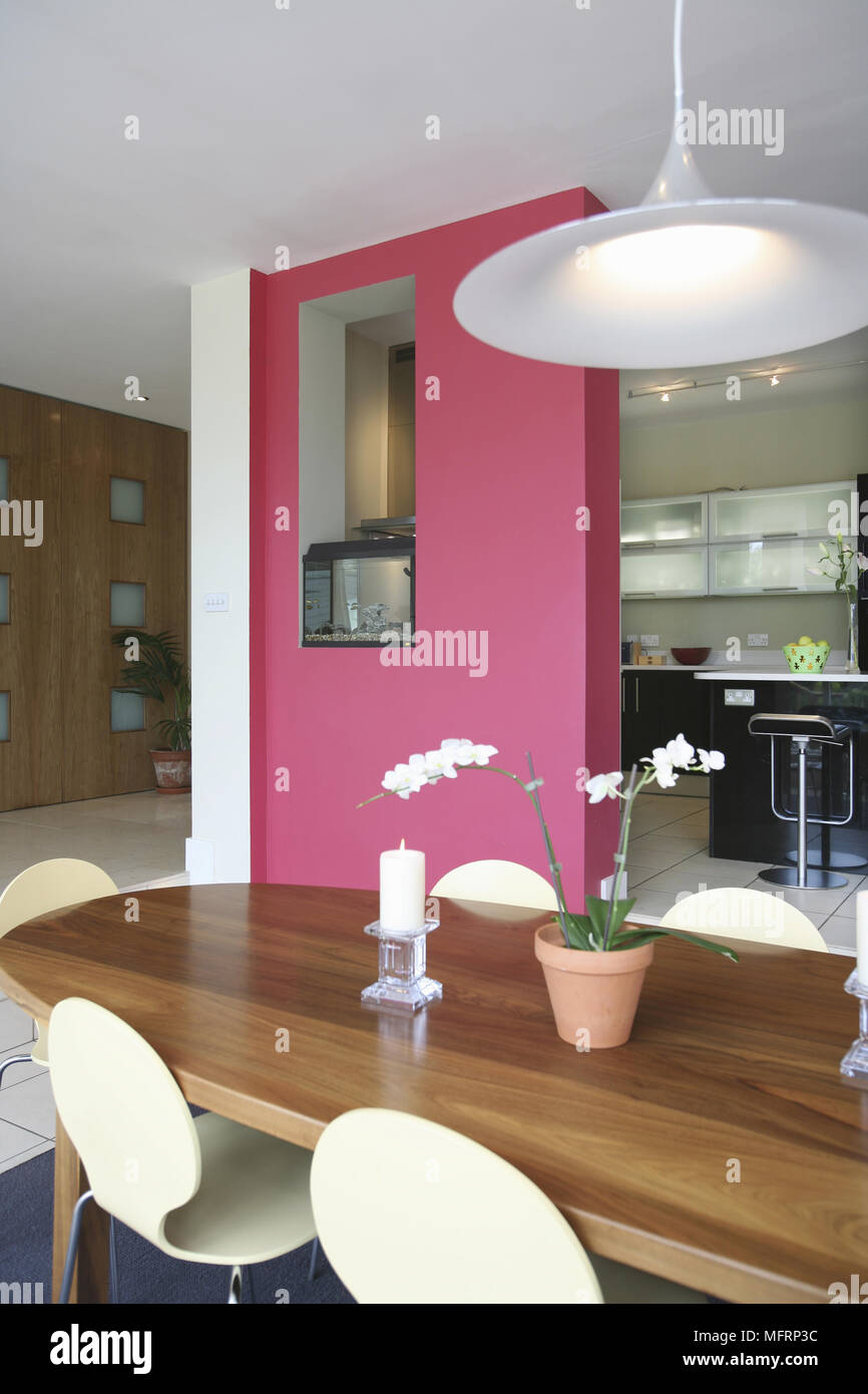 Rosa parete che divide la cucina dalla sala da pranzo con tavolo in legno e  sedie Foto stock - Alamy