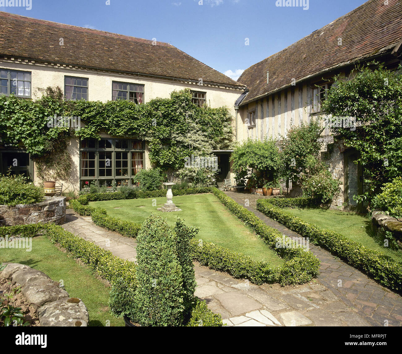 Esterno del Tudor casa colonica e fienile con giardino paesaggistico, Foto Stock