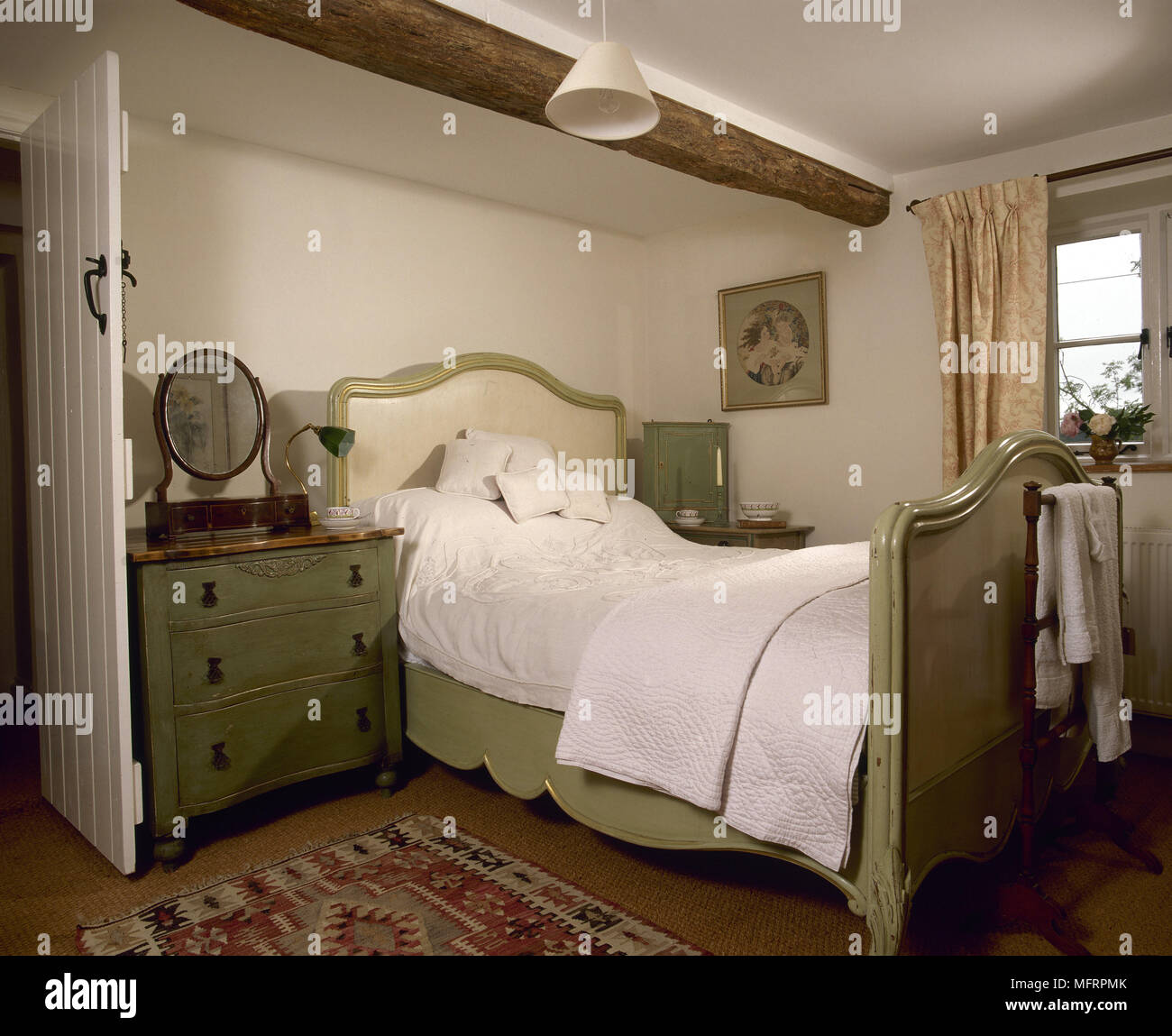 Paese camera da letto in legno con travi a soffitto dipinto letto alla francese e di un abbinamento di una cassettiera. Foto Stock