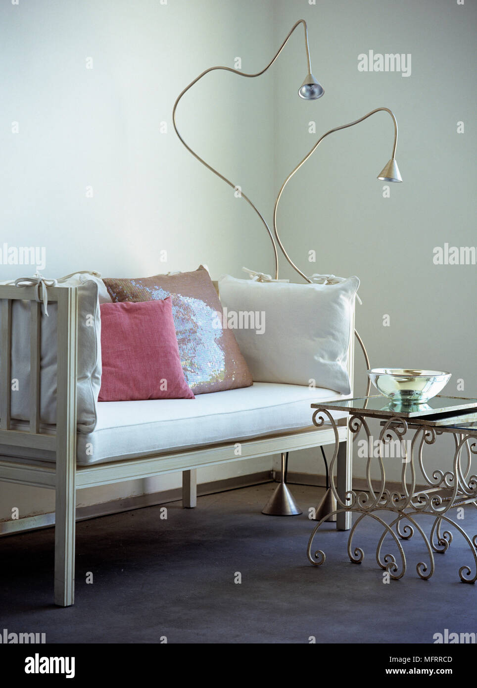 Moderne lampade da terra accanto al bianco divano in legno in un angolo della stanza Foto Stock