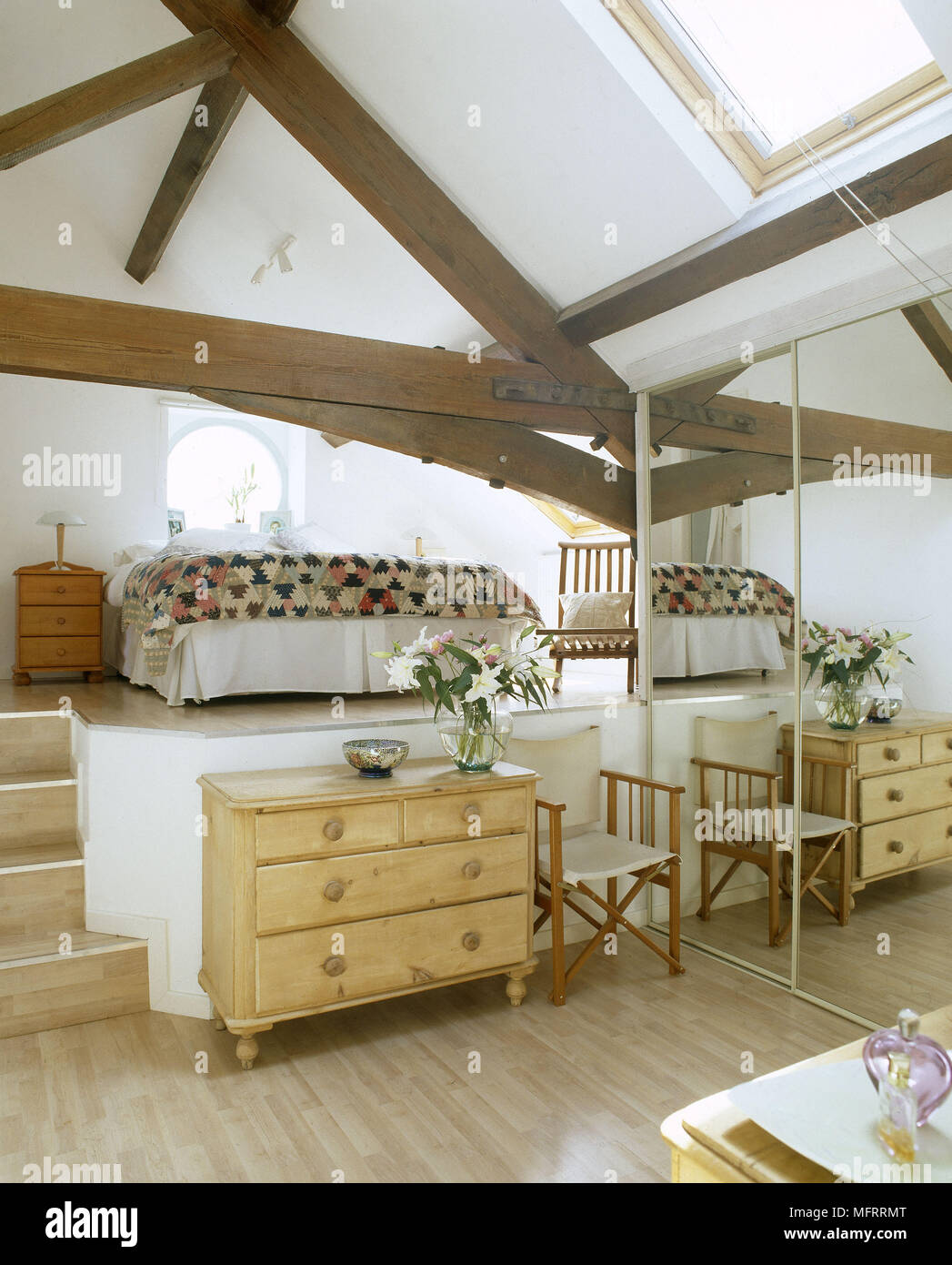 Stile country moderno livello diviso camera da letto con travi di pino letto Cassettiera armadi a specchio Foto Stock