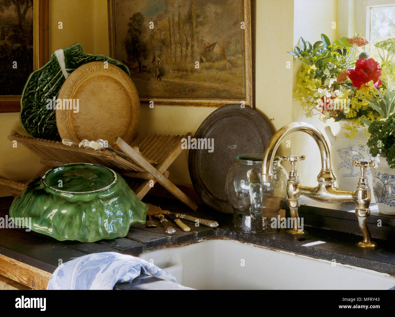 Un dettaglio di una cucina di paese che mostra un tradizionale Belfast lavandino piatto in legno sgocciolatoio piatti in ceramica Foto Stock