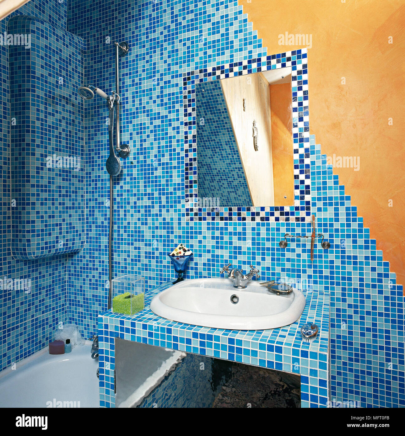 Bagno artistico con mosaico blu pareti piastrellate, vasca da bagno, lavandino e specchio. Foto Stock
