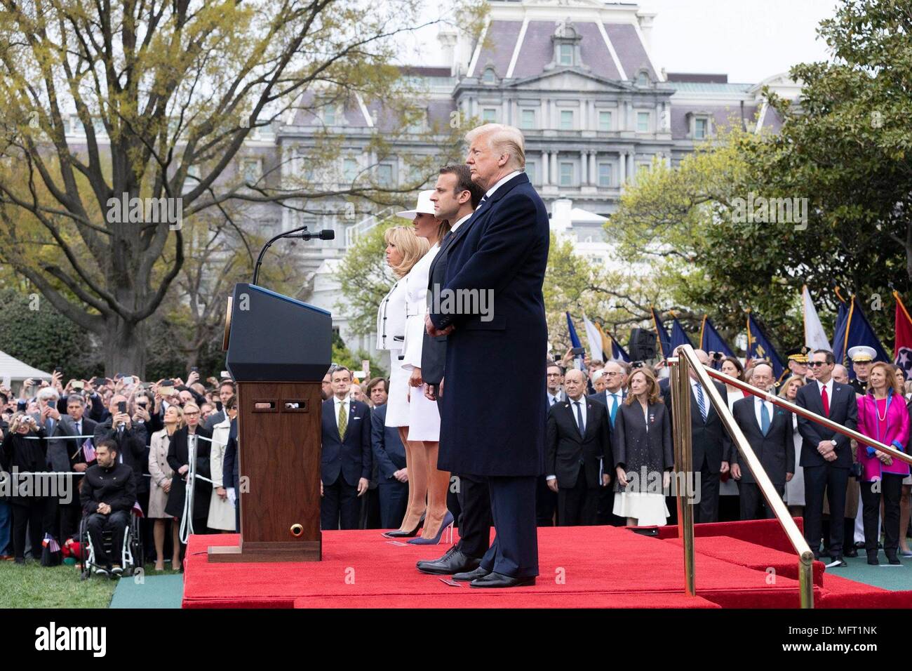U.S presidente Donald Trump, a destra il presidente francese Emmanuel Macron, First Lady Melania Trump e Brigitte Macron, sinistra, stand durante la solenne cerimonia di arrivo sul prato Sud della Casa Bianca Aprile 24, 2018 a Washington, DC. Macron è in visita di Stato a Washington la prima dal Presidente Trump ha preso l'ufficio. Foto Stock