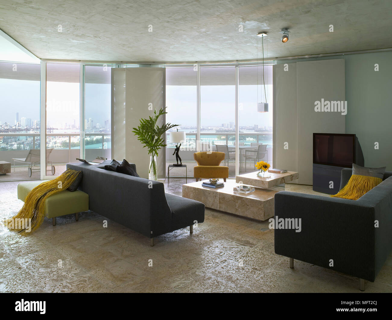 Un moderno salotto, il pannello di vetro pareti, divani imbottiti e poltrone, tavolo di pietra, pavimenti in pietra, Foto Stock