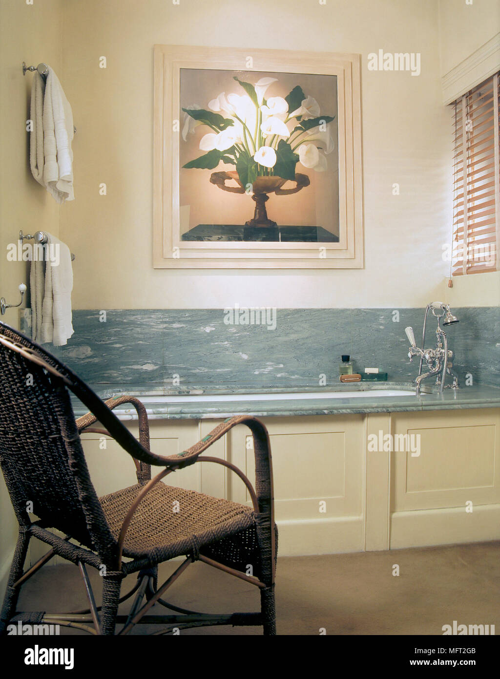 Un dettaglio di un bagno moderno, bagno attrezzato con pannelli anteriori e surround in marmo, sedia di canna Foto Stock