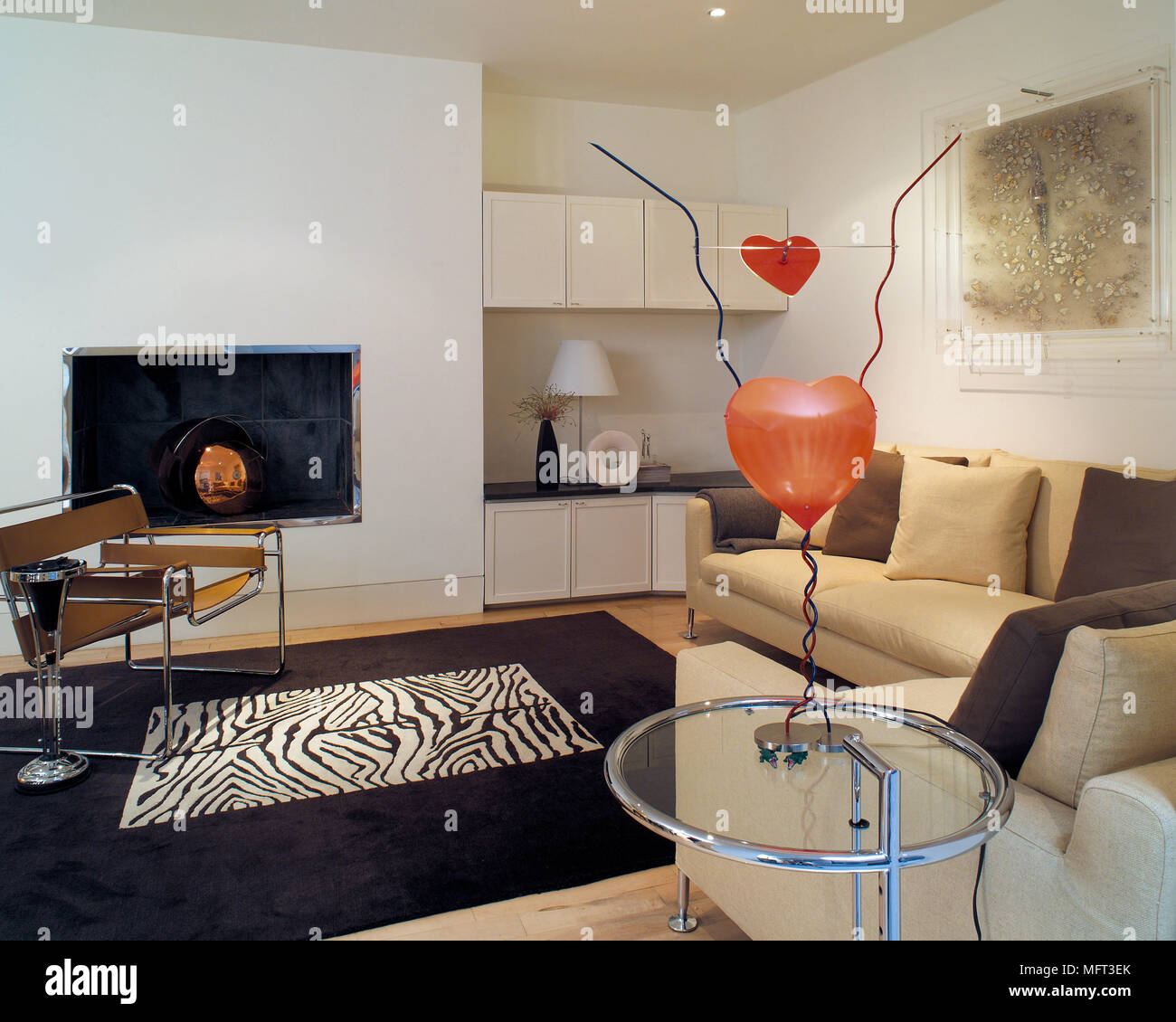 Marcel Breuer Wassily chrome e sedia in pelle nella parte anteriore del contemporaneo camino incassato con Eileen Gray tabella in primo piano Foto Stock