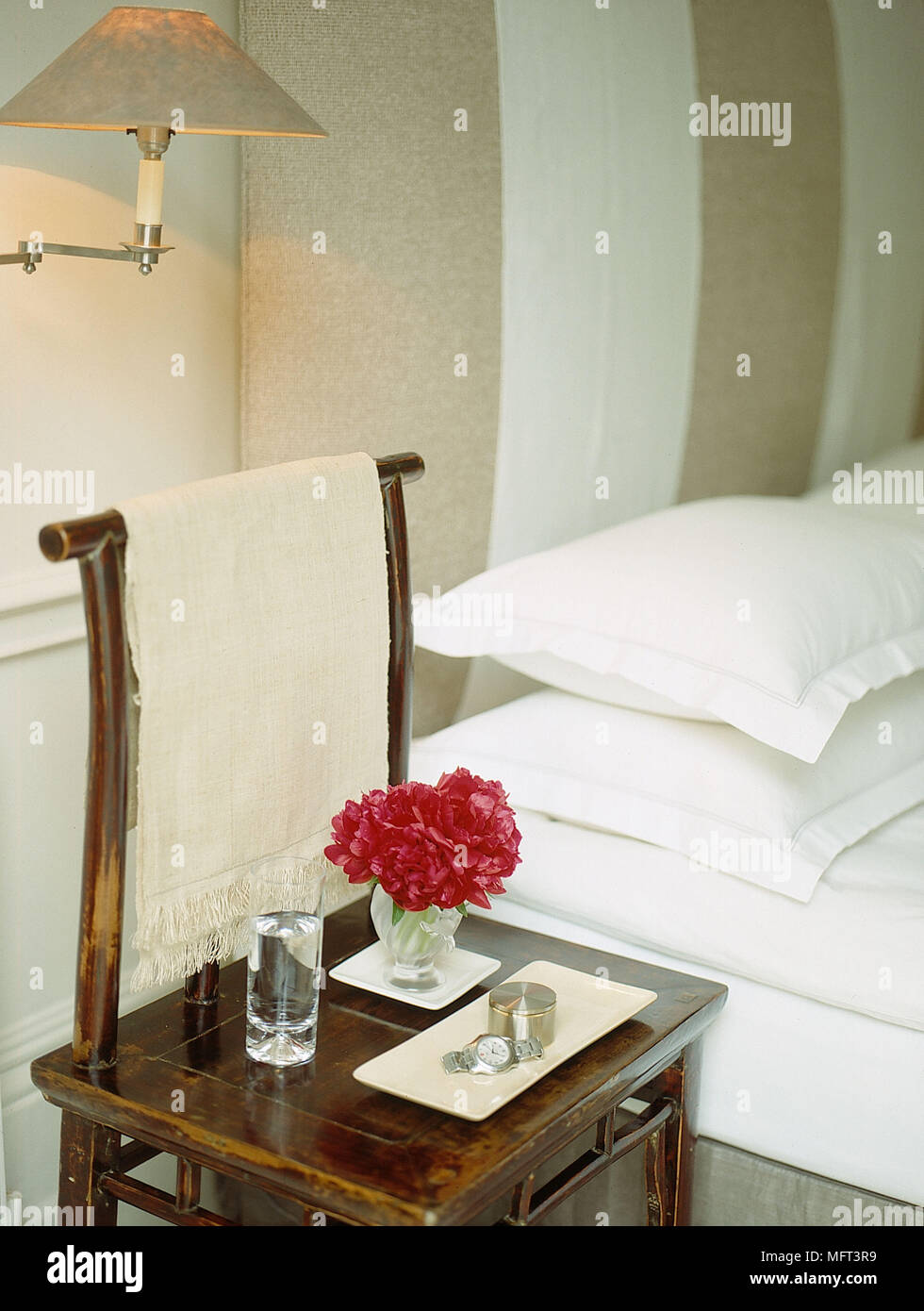 Camera Da Letto letto moderno arredamento orientale luce a parete su beige letto matrimoniale letto bianco copre e federe sedie lampada da parete in vetro di acqua di fiori in GLA Foto Stock