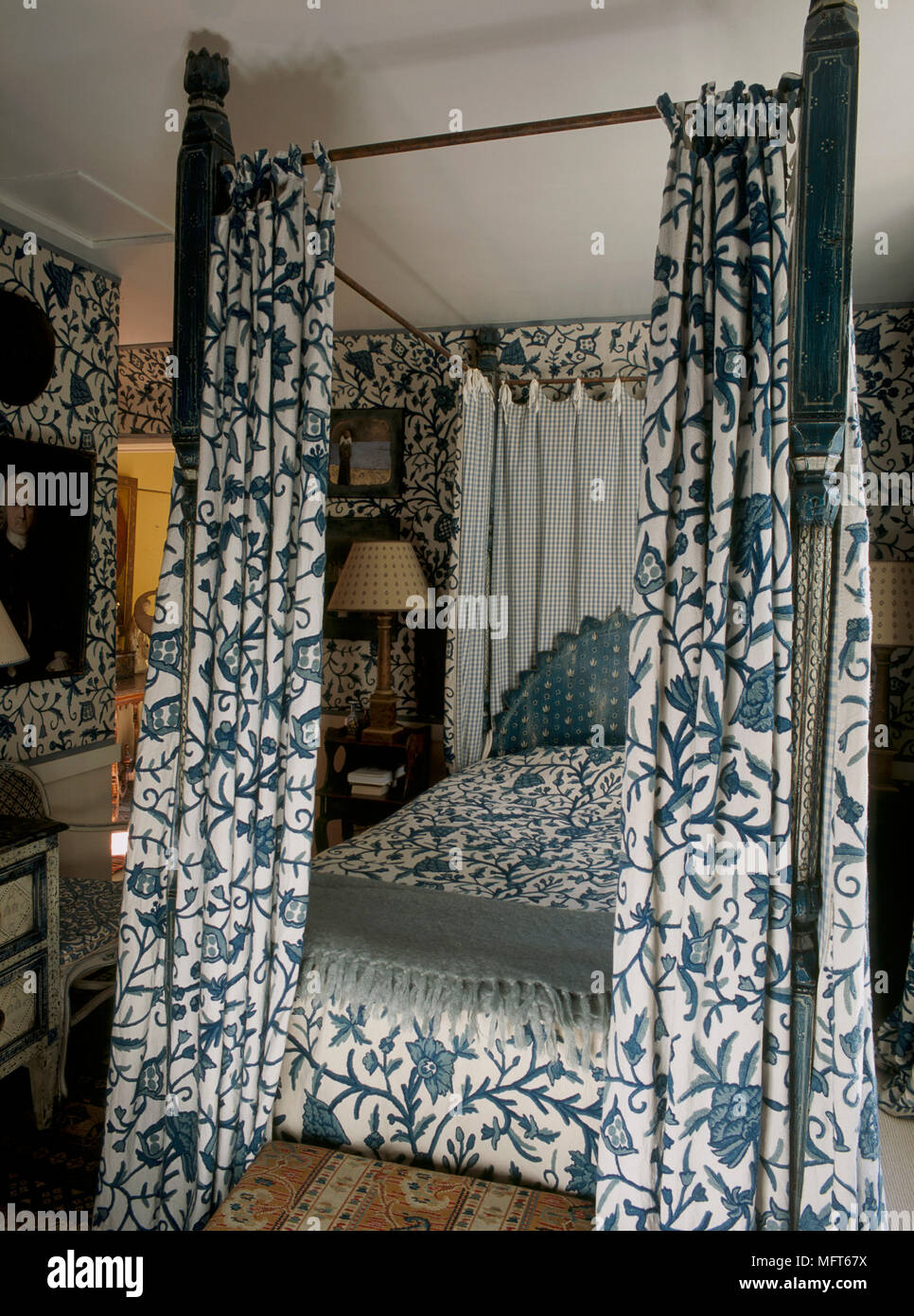 Camera da letto blu di pattern con carta da parati e copriletto coordinati  su un letto a baldacchino con tende Foto stock - Alamy
