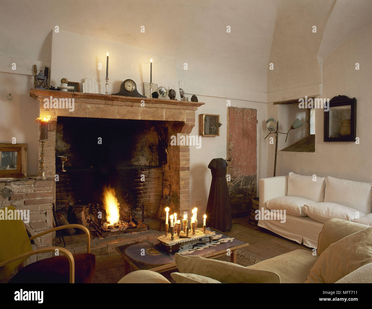 Paese rustica sala caminetto in mattoni ad aprire il fuoco divano tavolino interni camere caminetti fuochi accesi familiare caldi materiali naturali di colori Foto Stock