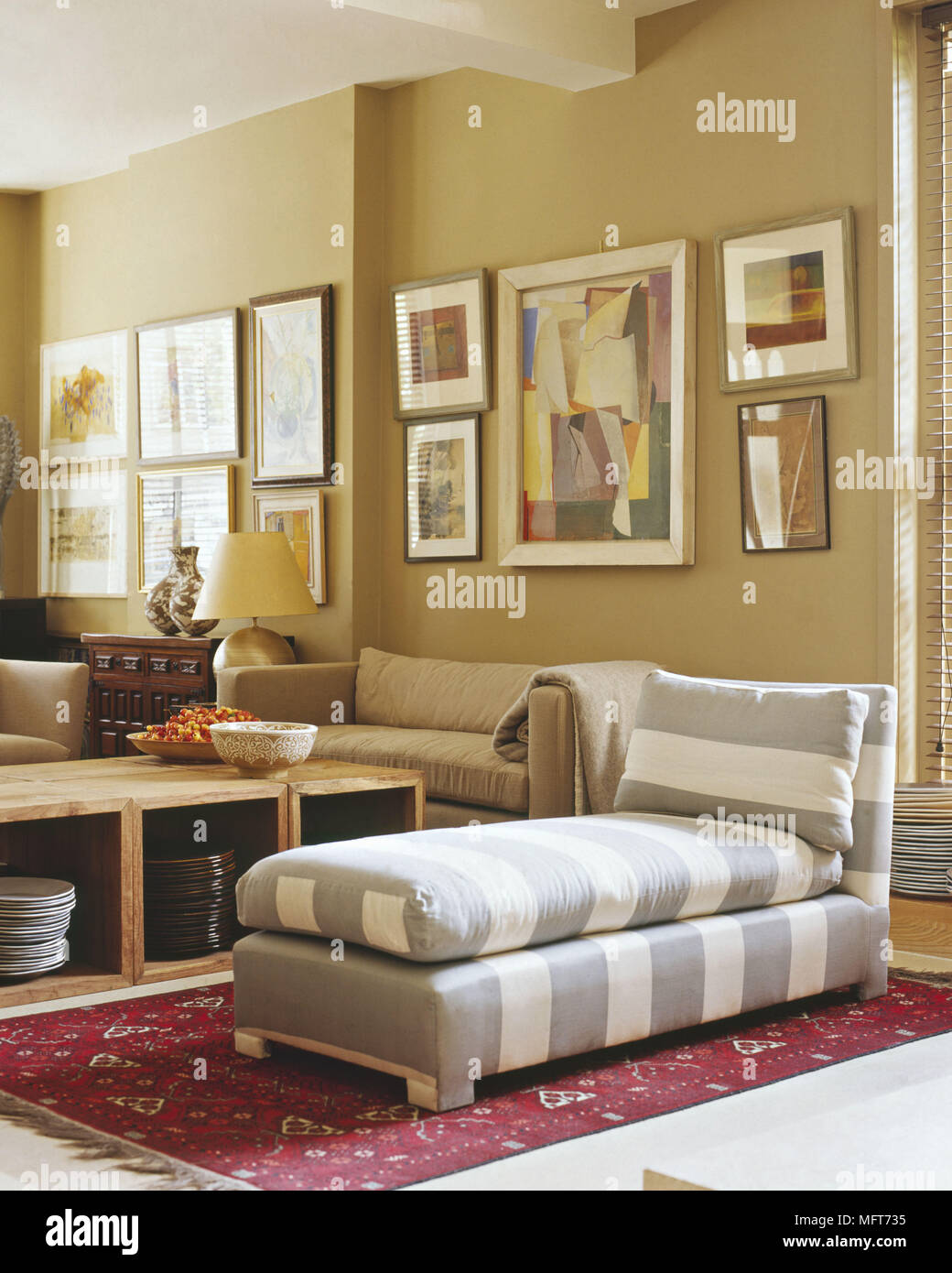 La stanza di seduta luce colorata divani pareti beige stoccaggio scatole striped chaise longue rug dipinti Interni camere moderne e contemporanee tavolo fatto di stor Foto Stock