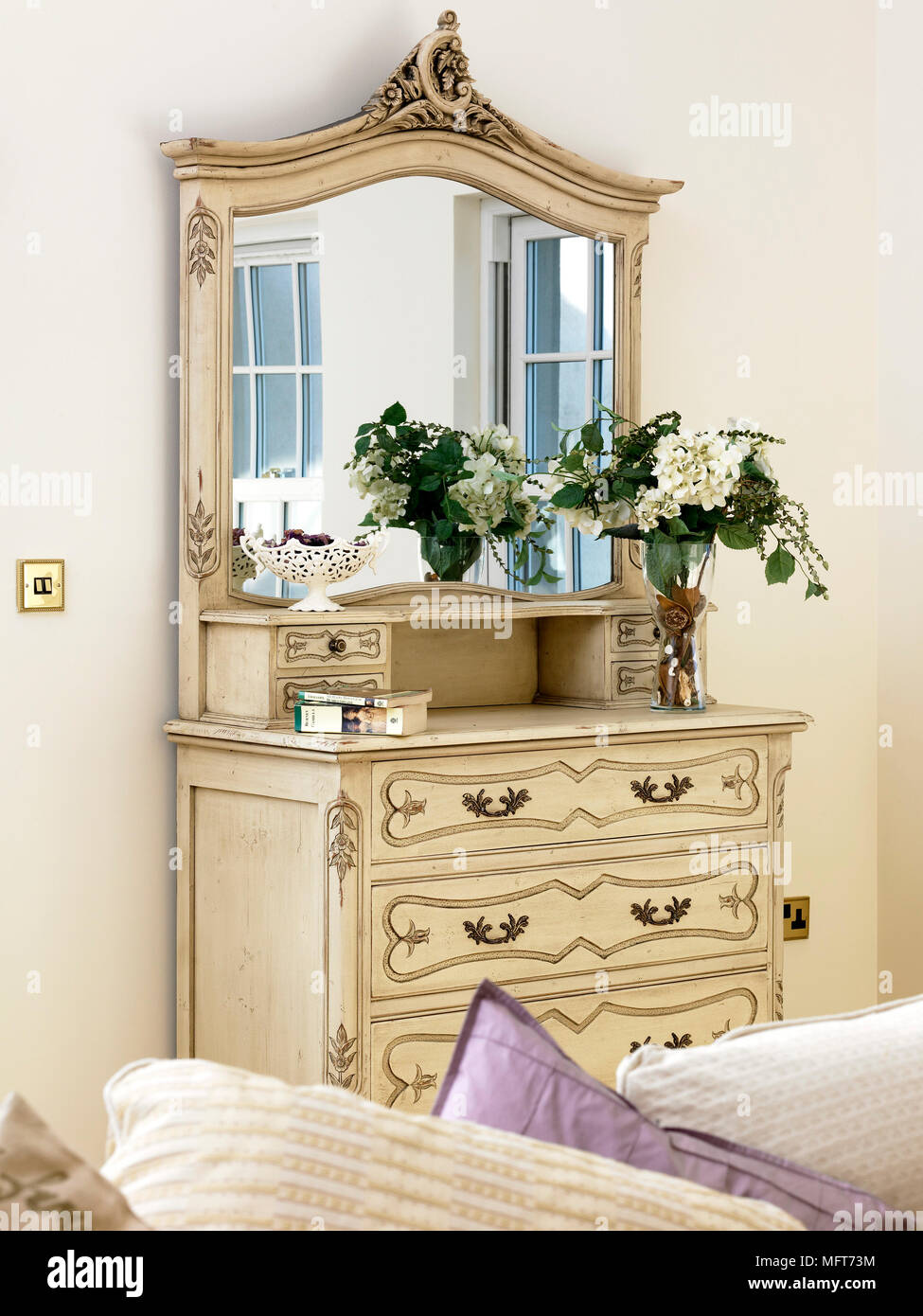 Un dettaglio di un tradizionale salotto decorativo in legno bianco cassettiera  con specchio, floreale Foto stock - Alamy