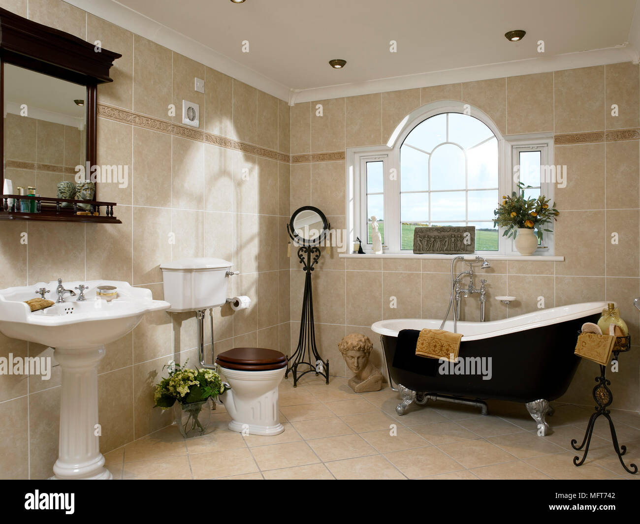 Uno stile tradizionale bagno con pareti piastrellate, un freestanding roll  top bagno in stile vittoriano colonna lavabo, WC, specchio, finestra Foto  stock - Alamy