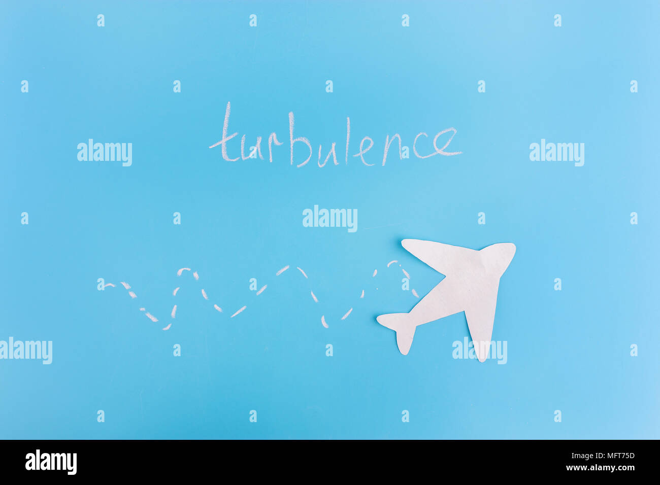 Aeroplano di carta su sfondo blu. concetto di turbolenza Foto Stock