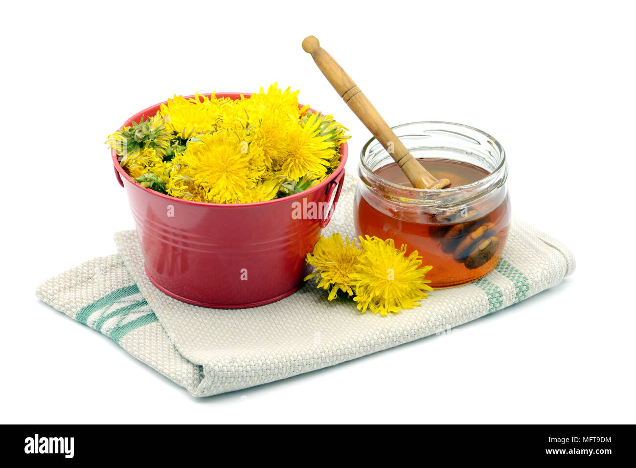 In casa di miele di dente di leone in un bicchiere e le teste dei fiori di tarassaco isolati a sfondo bianco. Foto Stock