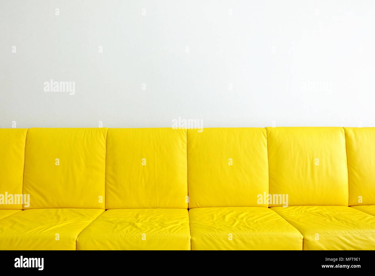 Divani gialli con muro bianco sullo sfondo. Foto Stock