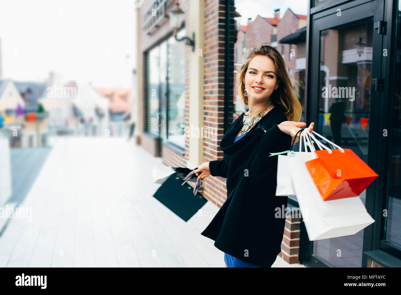 Bella donna con borse per lo shopping in città Foto Stock