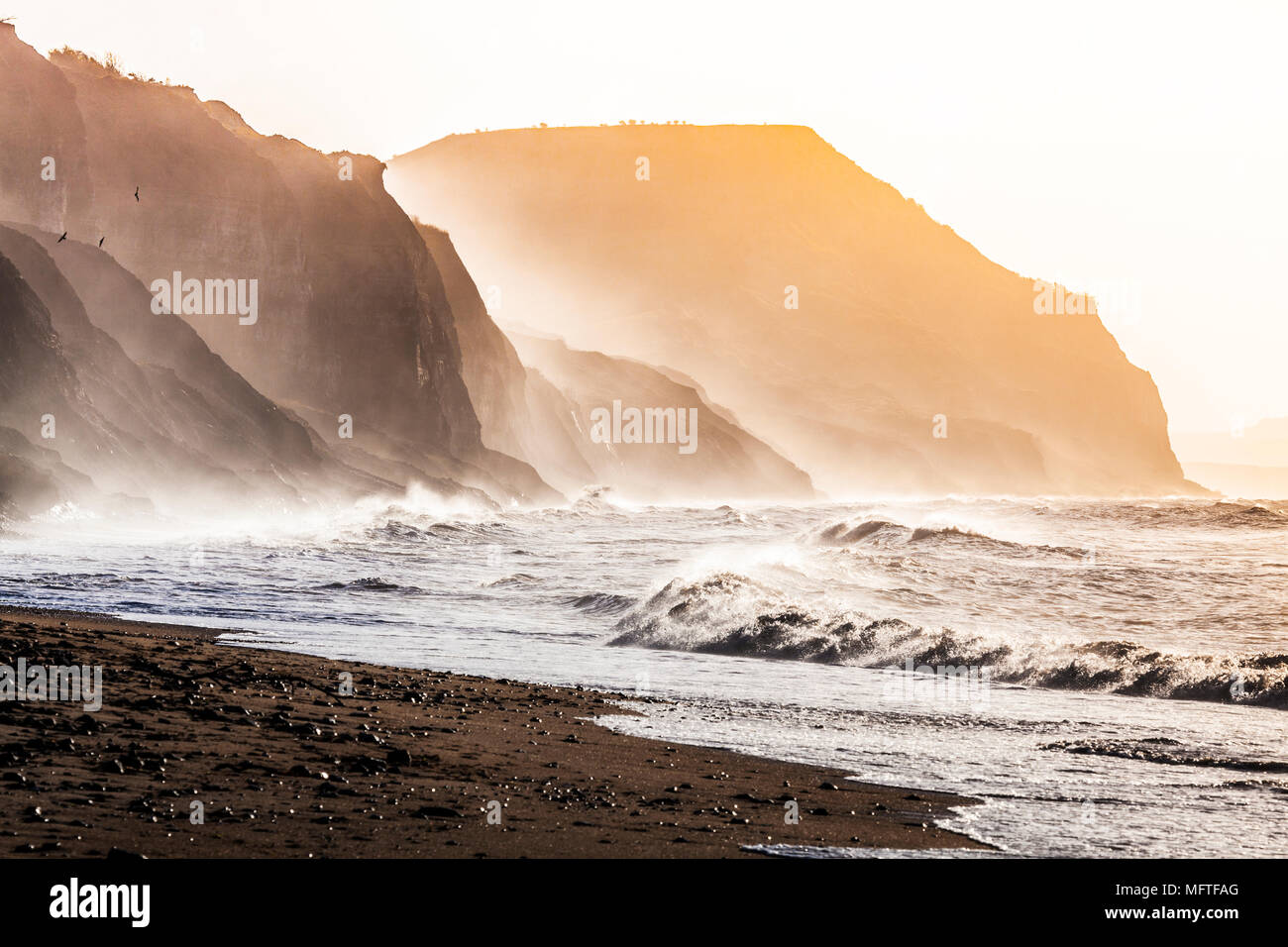 Tramonto sulla spiaggia di Charmouth guardando verso il Golden Cap. Foto Stock