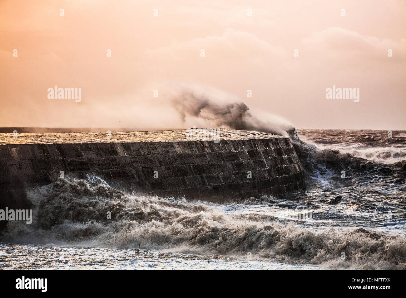 Onde infrangersi oltre il Cobb a Lyme Regis nel Dorset durante la tempesta Brian sabato 21 ottobre 2017. Foto Stock