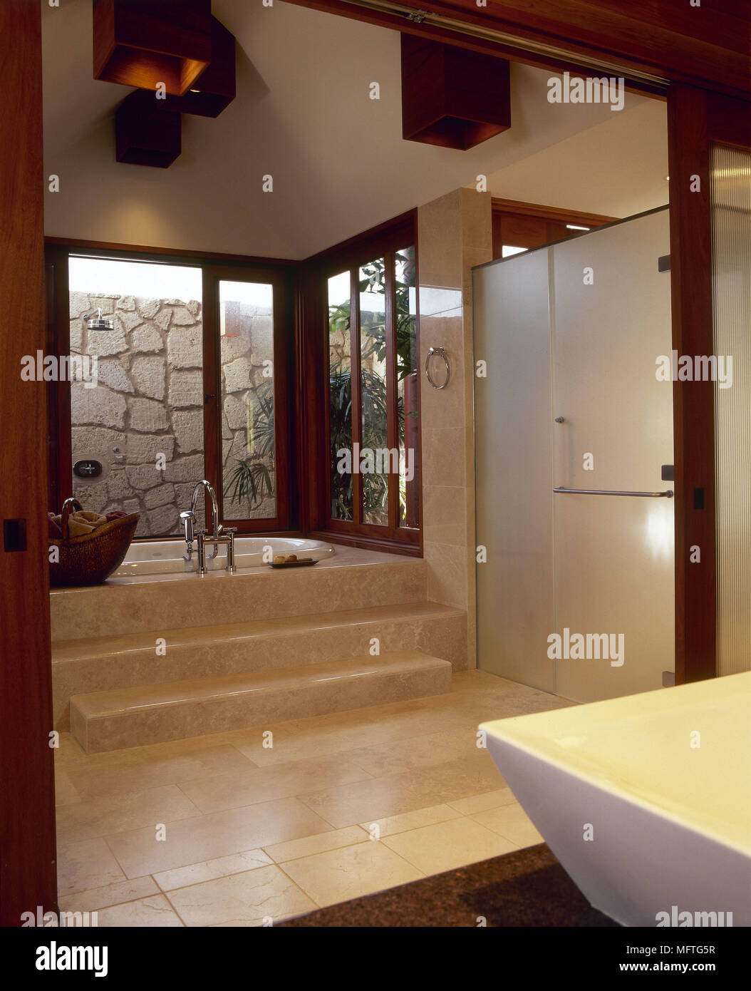 Bagno moderno passi per vasca da bagno incassata pavimento piastrellato interni Bagni Bagni Foto Stock