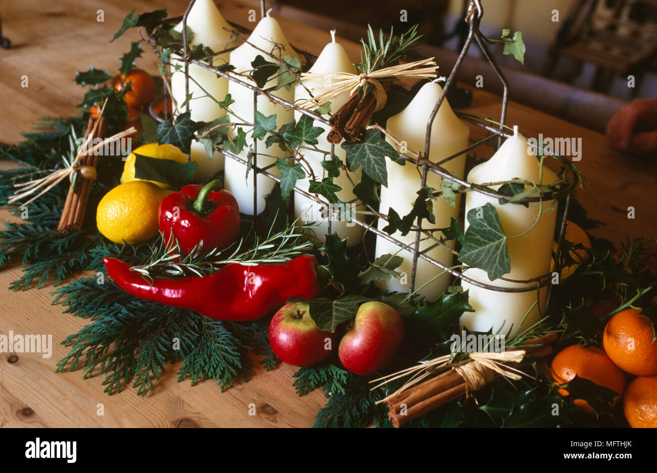 Tabella centrotavola di candele bianche nel telaio di filo, cucita con  foglie d'edera, peperoni, mele e limoni Foto stock - Alamy