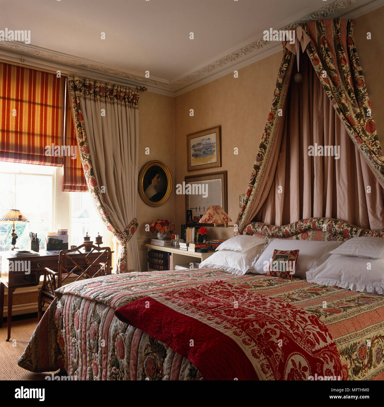 Letto matrimoniale con baldacchino di tessuto sopra il letto in camera da  letto in terracotta con arredi di coordinamento Foto stock - Alamy