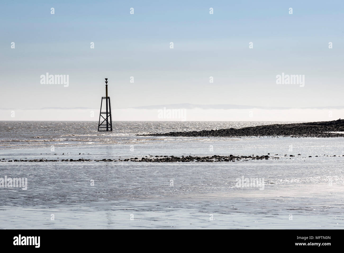 Un cardinale mark alla fine del freddo Knap punto, Barry su una luminosa giornata di sole ma con un mare di nebbia sul Canale di Bristol Foto Stock