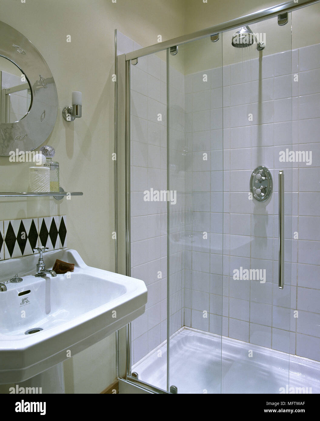 Un bagno moderno con pareti in crema lavabo doccia mensola in vetro Foto Stock