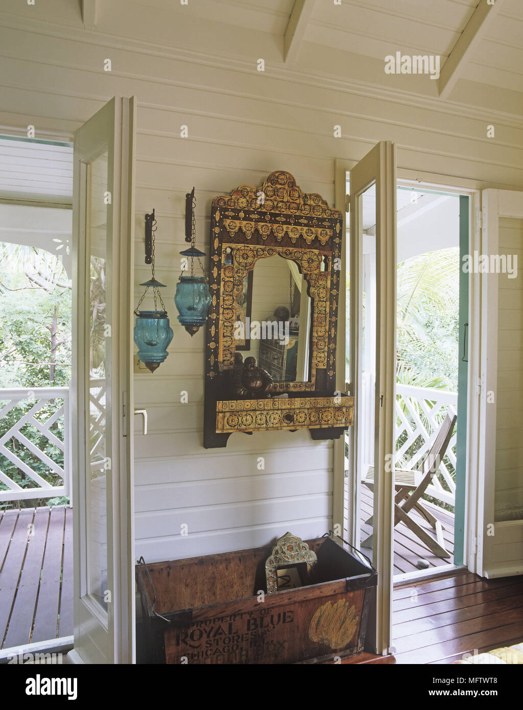 Dettagli di un ornato oro specchio decorativo in-tra due porte esterne e al di sopra di un antico scatola di legno. Foto Stock