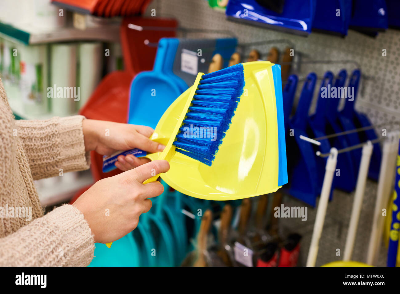 La donna le mani con la spazzola di pulizia e un convogliatore in negozio Foto Stock