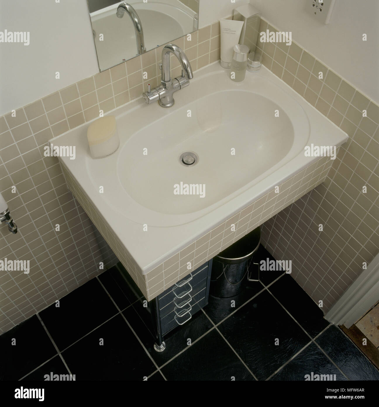 Un dettaglio di un bagno moderno che mostra una parete montata lavabo con mosaico surround e pareti Foto Stock
