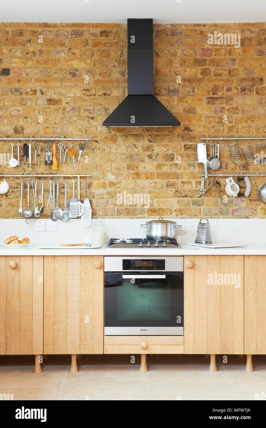 Cappa su fornelli a gas e forno in cucina moderna con mattoni a vista la  parete Foto stock - Alamy