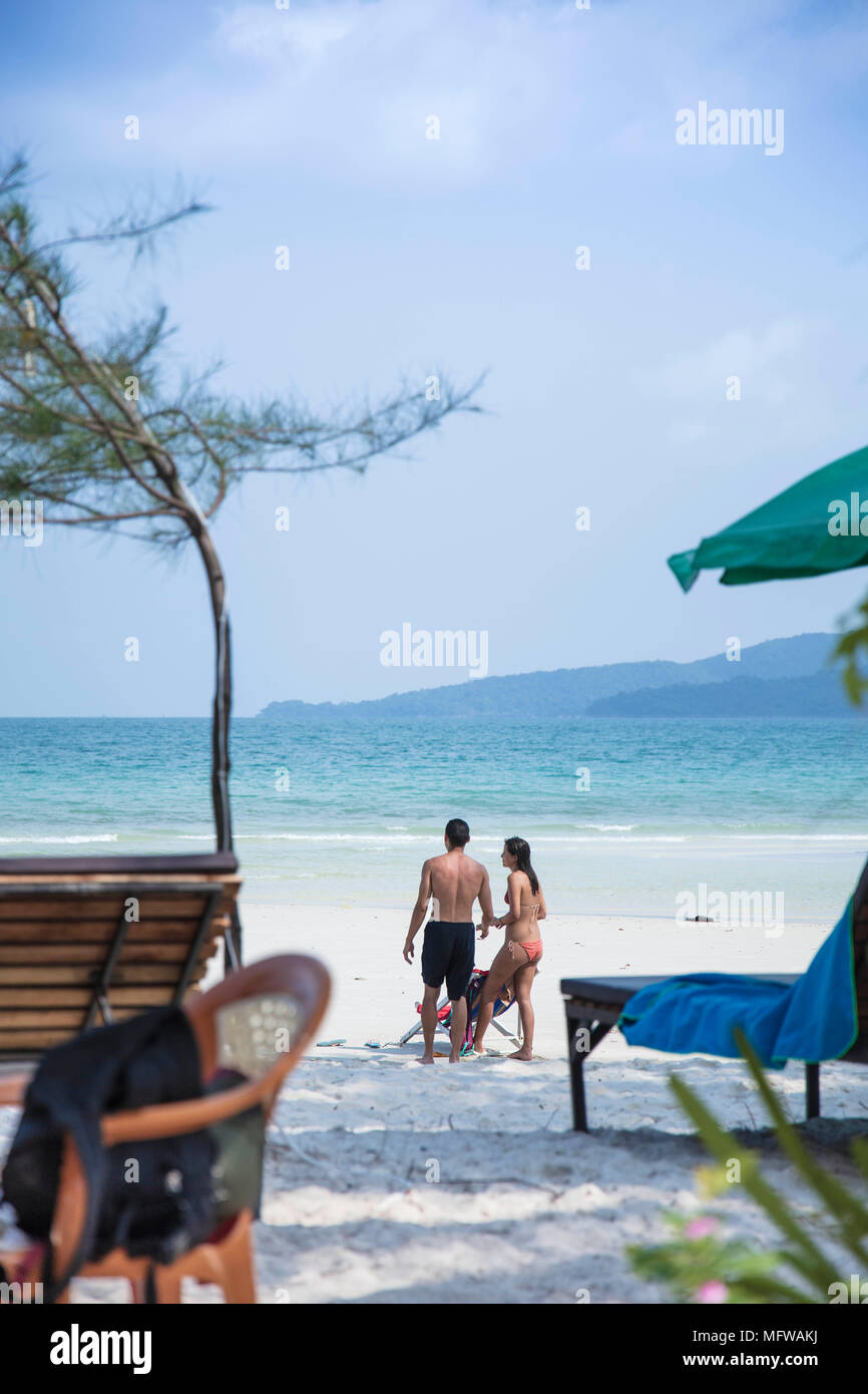 Candide colpo di una giovane coppia di parlare su una spiaggia di sabbia bianca su di un isola nel sud-est asiatico Foto Stock