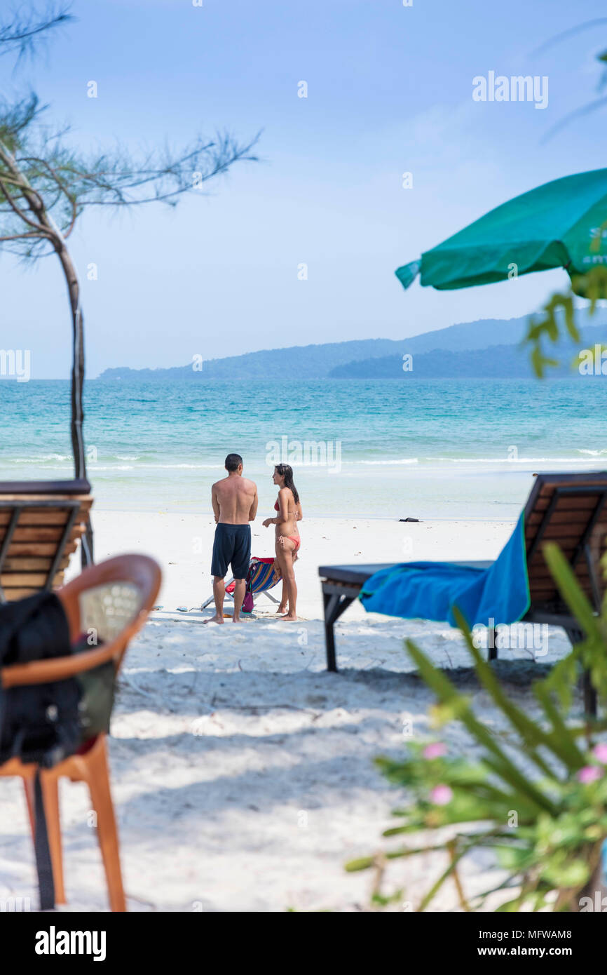 Candide colpo di una giovane coppia di parlare su una spiaggia di sabbia bianca su di un isola nel sud-est asiatico Foto Stock