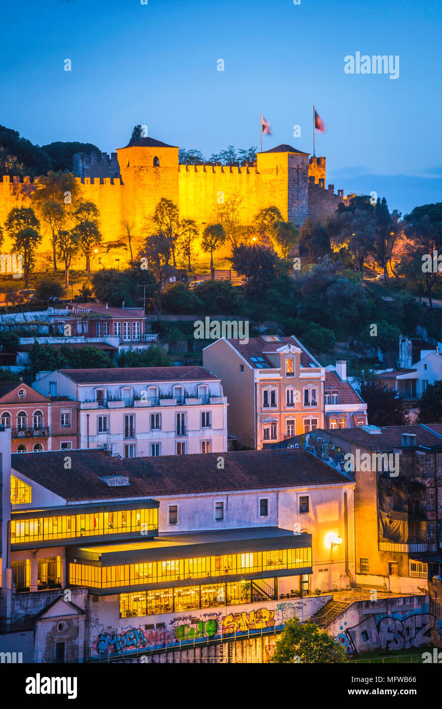 Lisbona portogallo città, vista del Castelo de Sao Jorge illuminata di notte con le affollate hillside edifici del quartiere Mouraria situati al di sotto. Foto Stock