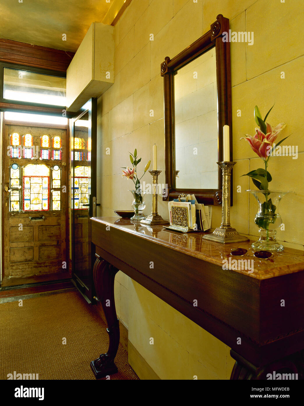 Un corridoio tradizionale con pareti di pietra, tavolino, piano in marmo, porta anteriore, vetrate, Foto Stock