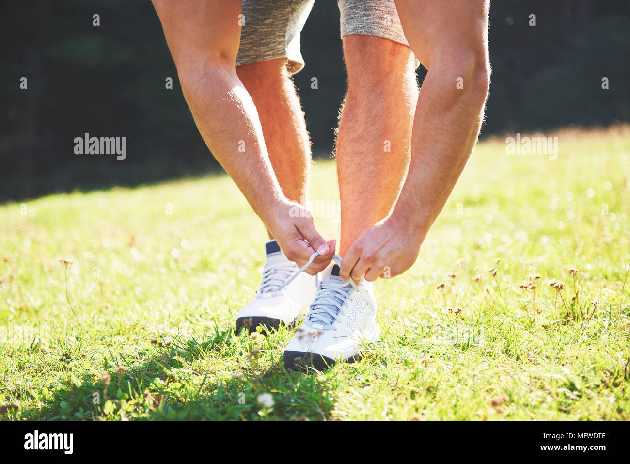 Legatura di calzatura sportiva. Un giovane atleta ottenere pronto per l'uso sportivo e allenamento fitness all'aperto. Sport, esercizio, fitness, allenamento. Uno stile di vita sano Foto Stock