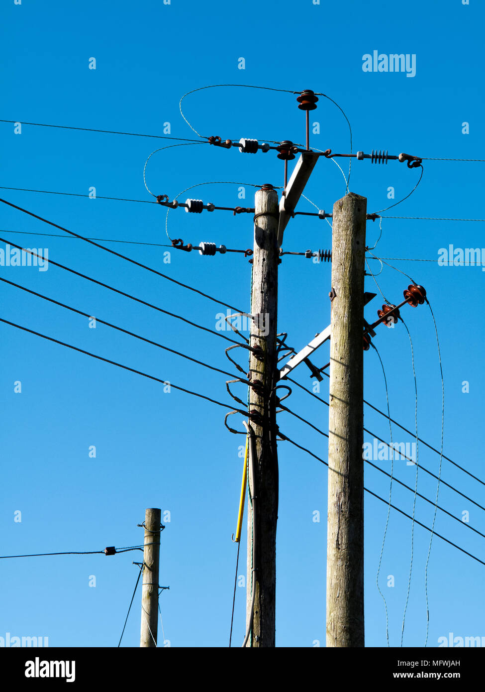 Tettuccio elettrico trasmissione di alimentazione e i cavi di distribuzione contro un cielo blu chiaro Foto Stock