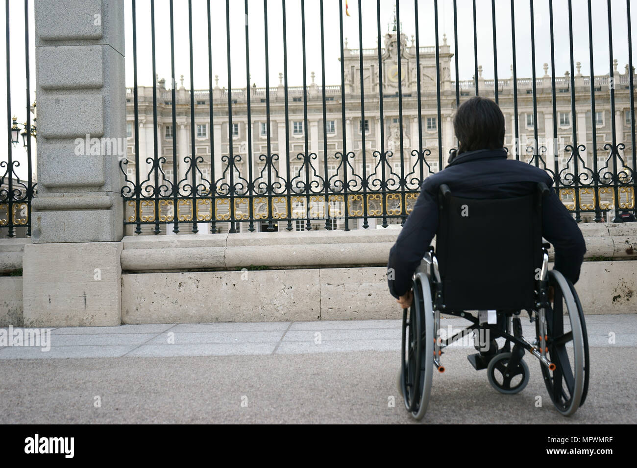 Uomo sulla sedia a rotelle in plaza Armeria, Madrid, Spagna Foto Stock