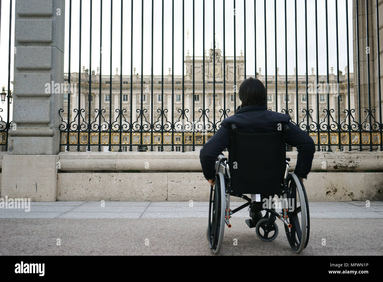 Uomo sulla sedia a rotelle in plaza Armeria, Madrid, Spagna Foto Stock