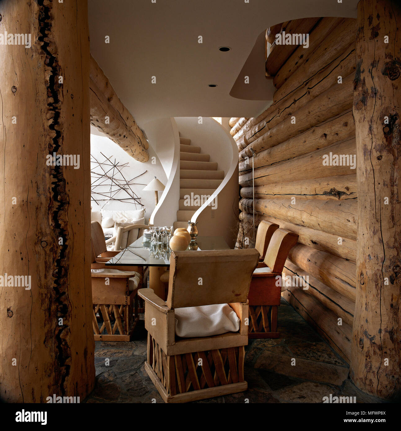 Sala da pranzo in legno con pareti di log e scalinata curva. Foto Stock