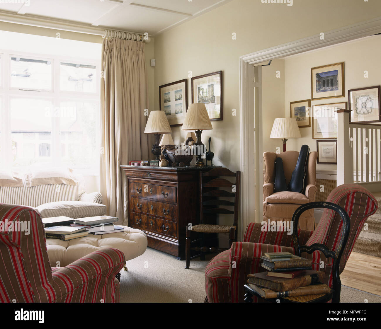 Poltrone imbottite con striscia rossa tessuto in salotto con finestre a parete Foto Stock