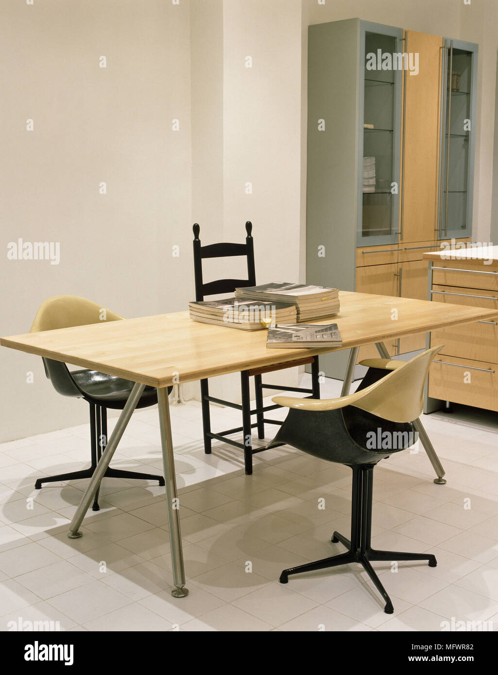 Tavolo da pranzo con piano in legno e gambe in metallo e sedie girevoli Foto Stock