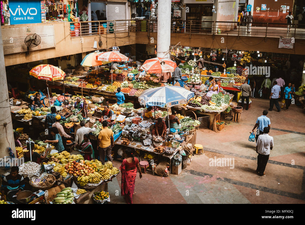 Colorata frutta occupato e produrre sul mercato un giorno caldo tropicale in Goa, India Foto Stock