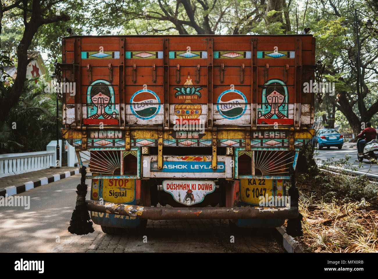 Retro del carrello coperto di adesivi parcheggiato su una strada in un giorno caldo in Goa, India Foto Stock