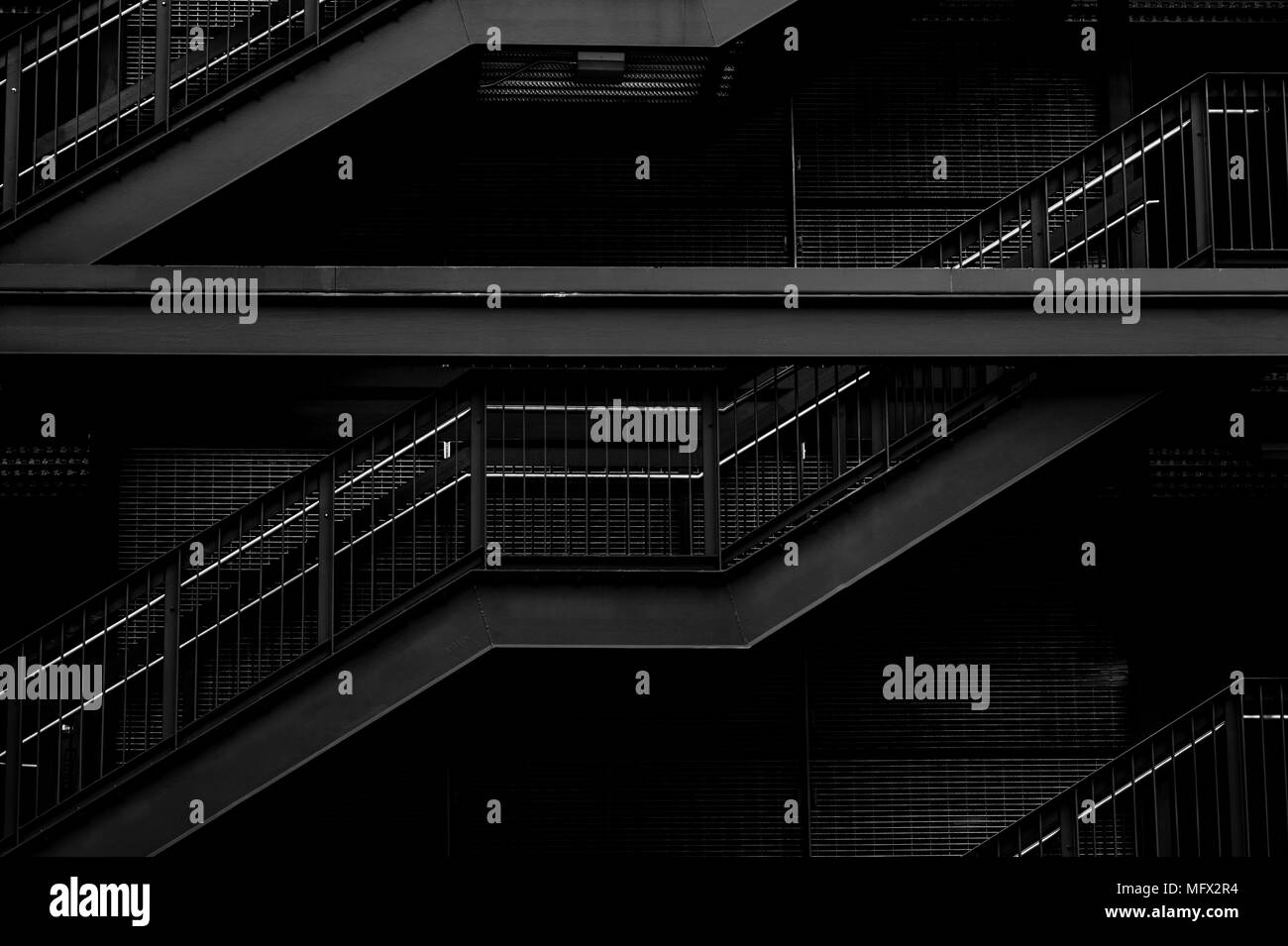 Garage esterno multilivello con primo piano di scale metalliche con ringhiere evidenziate Foto Stock