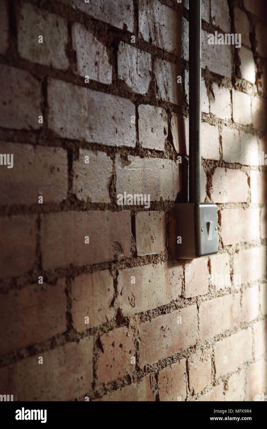Interruttore luce montata su un nudo muro di mattoni Foto stock - Alamy