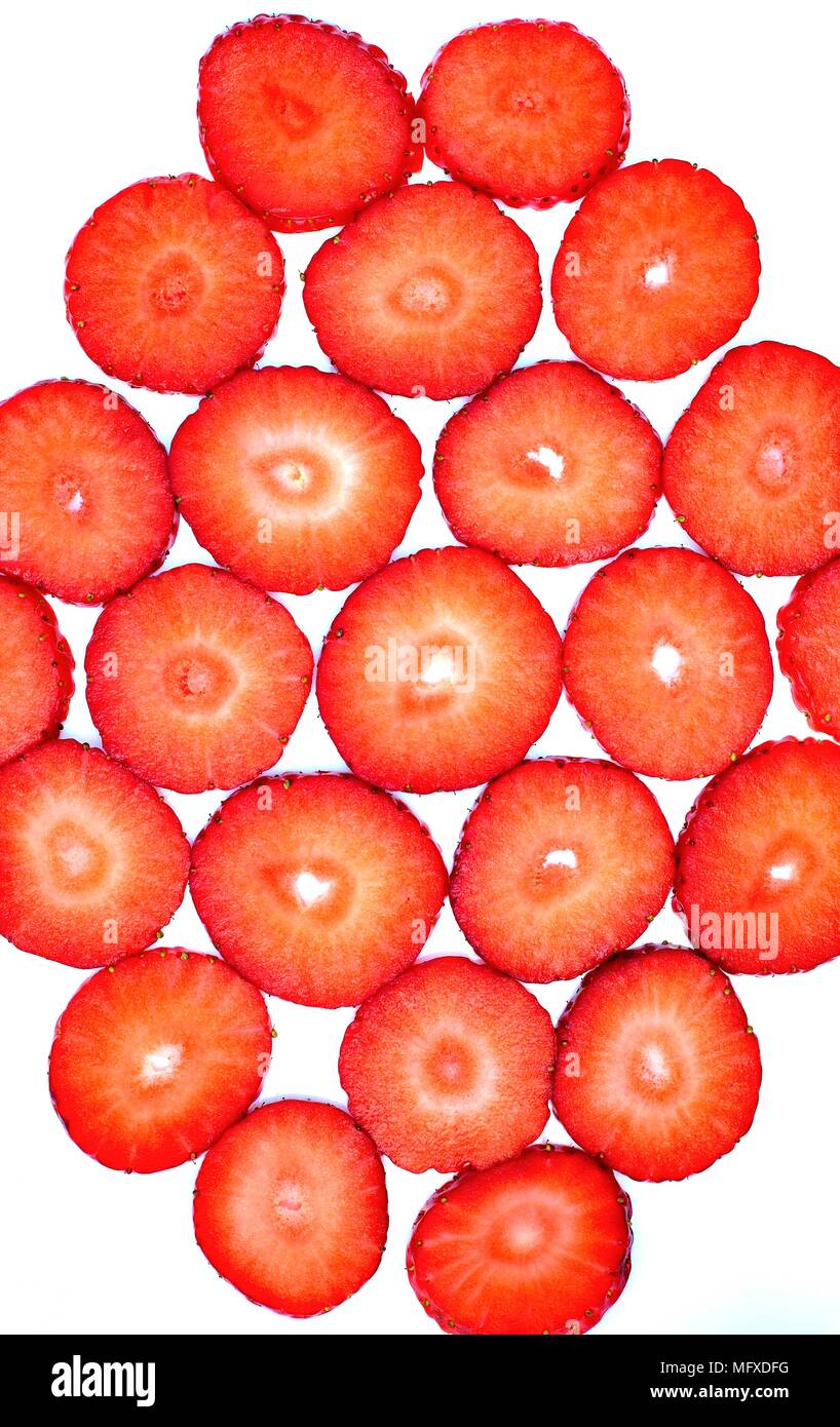 Texture, sfondo, astratta e fruttato concetto: pattern con rosso fragole tagliate su uno sfondo bianco. Foto Stock