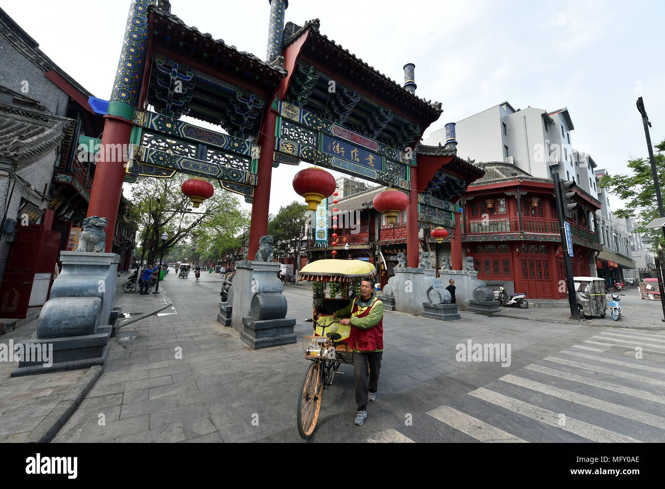 (180427) -- ZHENGZHOU, 27 aprile 2018 (Xinhua) -- Xu Shijie, un pedicab driver, attende i clienti a Shudian street di Kaifeng, centrale cinese della Provincia di Henan, 26 aprile 2018. Il 51-anno-vecchio Xu Shijie, o Jason in inglese è un pedicab driver. Come molti pedicab driver non è in grado di parlare inglese, Xu che ama leggere libri in inglese nel suo tempo libero si distingue. Poiché Xu ha incontrato il suo primo cliente straniero nel 2003, egli ha determinato per migliorare il suo inglese ascolto e abilità di conversazione. Xu praticata inglese ogni giorno e ora egli può introduce il Kaifeng storia, punti panoramici e usanze popolari in inglese fluentl Foto Stock